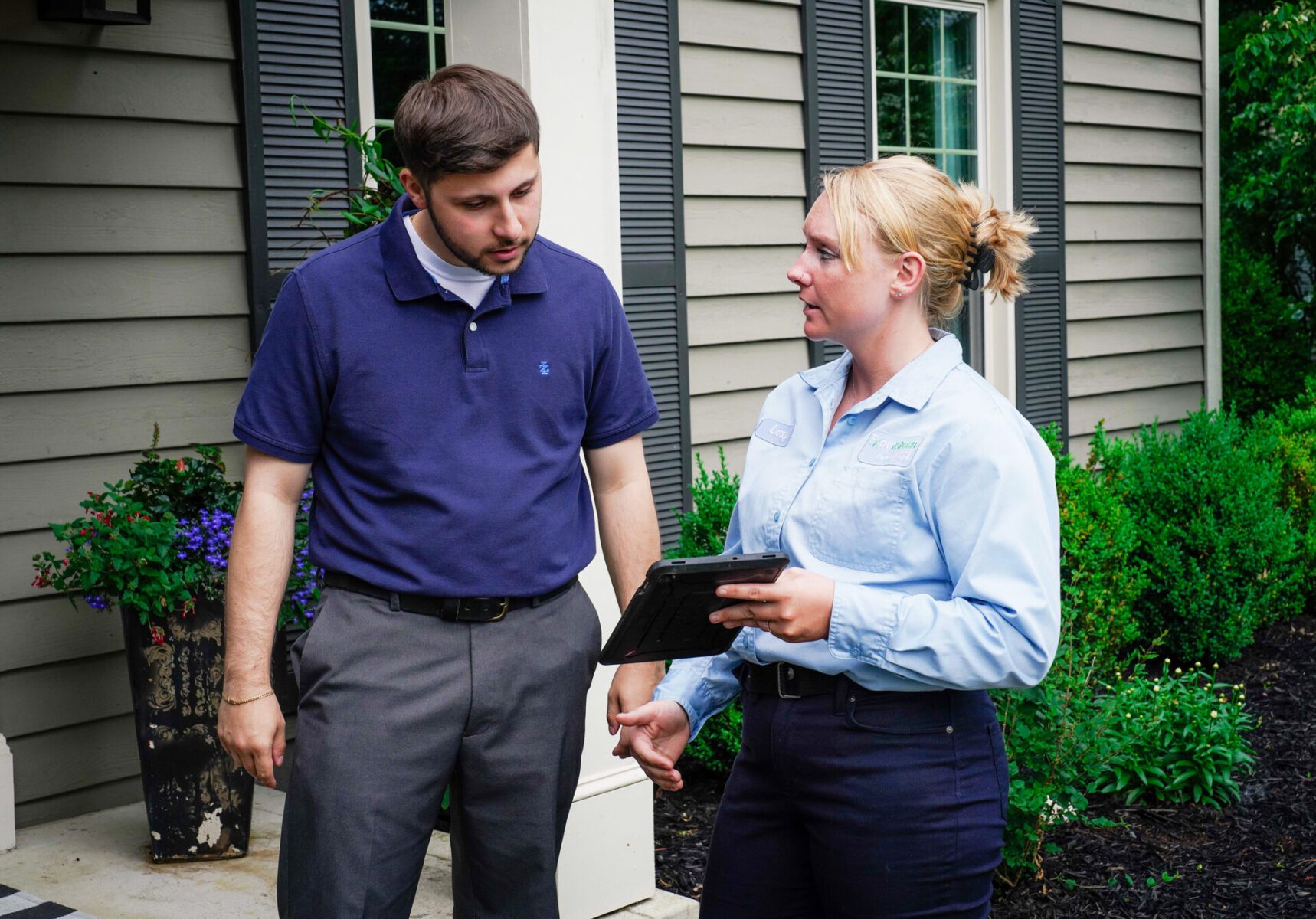 Lawn technician talking to customer on porch