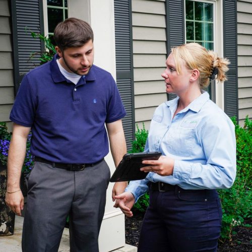 ExperigreenD1-52 Lawn technician talking to customer on porch